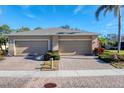 Tan two-unit house with a three-car garage and a well-maintained yard at 13542 Abercrombie Dr, Englewood, FL 34223