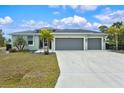 Charming single-story home featuring a three-car garage and a well-maintained front yard, perfect for curb appeal at 14098 Baracoa Ln, Port Charlotte, FL 33981