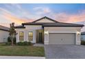 One-story home with gray siding and a two-car garage at 14454 Little Eagle Loop, Nokomis, FL 34275