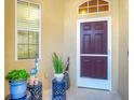 Elegant front door entry with a screen door and potted plants at 1584 Monarch Dr, Venice, FL 34293