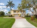 Two-story house with a large driveway and tropical landscaping at 1784 Bayshore Dr, Englewood, FL 34223