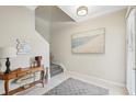 Bright entryway with staircase, console table, and coastal art at 23471 Awabuki Dr, Venice, FL 34293