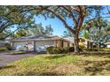 A three-car garage, mature landscaping, and a spacious yard with large oak trees at 237 Southampton Ln # 275, Venice, FL 34293