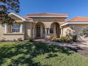 One-story house with arched entryway, tile roof, and lush landscaping at 298 Montelluna Dr, North Venice, FL 34275