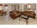 Spacious living room with two brown sofas and a glass-top coffee table at 298 Montelluna Dr, North Venice, FL 34275