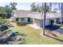 Charming one-story home featuring an attached garage and a well-maintained lawn and mature landscaping at 301 Pinebrook Club Dr # 1, Venice, FL 34285