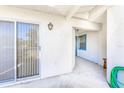 Cozy covered patio with sliding glass doors and a well-maintained concrete flooring at 301 Pinebrook Club Dr # 1, Venice, FL 34285