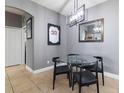 Small dining area with glass table and four black chairs at 320 Langholm Dr, Venice, FL 34293