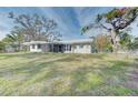 Large backyard with a spacious house and mature trees at 324 Monet Dr, Nokomis, FL 34275