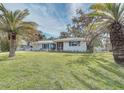 Newly renovated home with a spacious lawn and palm trees at 324 Monet Dr, Nokomis, FL 34275
