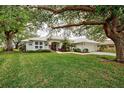 House with a tile roof, large trees, and a well-maintained lawn at 339 Meadow Beauty Ct, Venice, FL 34293