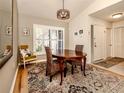 Bright dining room features wood floors and charming table setting at 341 Pembroke Ln # 227, Venice, FL 34293