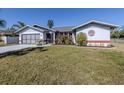 Single story home with a two-car garage, and nicely landscaped lawn at 4060 Barbary Ln, North Port, FL 34287