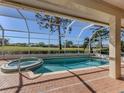 Inviting pool and spa with a screened enclosure and golf course view at 487 Summerfield Way, Venice, FL 34292