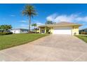 Long driveway leading to a yellow house with a white garage door at 49 Perimeter Dr, Englewood, FL 34223