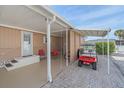 Covered patio with seating area and golf cart, adjacent to the house at 521 Roma Road, Venice, FL 34285