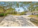 Long driveway leading to a house and garage, surrounded by trees at 610 Woodview Way, Bradenton, FL 34212