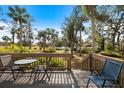 Private deck with table and chairs, overlooking lush tropical landscape at 784 Bird Bay Way # 105, Venice, FL 34285