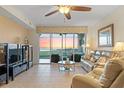 Bright living room with tile floors, comfortable seating, and stunning water views from the balcony at 9203 Griggs Rd # B202, Englewood, FL 34224