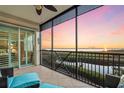 Relaxing screened porch with blue patio chairs and lovely views of the water at 9203 Griggs Rd # B202, Englewood, FL 34224