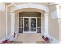 Elegant entryway with decorative iron screen doors and columns at 1010 Grouse Way, Venice, FL 34285