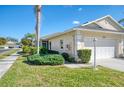 Exterior view of a villa with a white garage door and well-maintained landscaping at 1102 Auburn Cove Cir, Venice, FL 34292