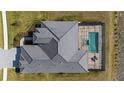 Aerial view of the home showcasing the roof, pool, and surrounding landscape at 11140 Hogan Cir, Englewood, FL 34223