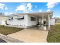 White single-wide mobile home with carport at 115 White Oak Way, Sarasota, FL 34237