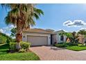 Well-maintained house with a brick driveway and lush landscaping at 11692 Spotted Margay Ave, Venice, FL 34292
