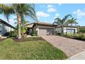 Single-story house with a brown garage door and a brick driveway at 12861 Oriago St, Venice, FL 34293