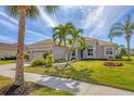 Beautiful single-Gathering home with mature palms, manicured lawn and a beige exterior at 357 Marsh Creek Rd, Venice, FL 34292