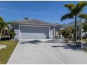 Gray house with attached garage and landscaped yard at 4251 Oak Terrace Cir, Port Charlotte, FL 33953