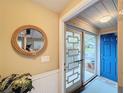 Bright entryway with a rope mirror and blue door leading outside at 500 Park S Blvd # 7, Venice, FL 34285