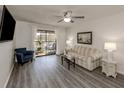 Bright living room with wood flooring, a ceiling fan, and sliding glass doors to the balcony at 503 Albee Farm Rd # B-14, Venice, FL 34285