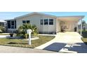 Mobile home with carport, large yard, and driveway at 563 Portside Dr, North Port, FL 34287