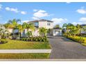 Two-story house with gray walls, tile roof, and a three-car garage at 7484 Ripetta St, Sarasota, FL 34240