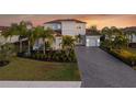Two-story house with gray walls, tile roof, and a three-car garage at 7484 Ripetta St, Sarasota, FL 34240