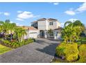 Two-story house with gray walls, tile roof, and a three-car garage at 7484 Ripetta St, Sarasota, FL 34240