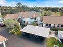 Exterior aerial view of a well-maintained condo with a carport, surrounded by lush landscaping at 854 Bird Bay Way # 190, Venice, FL 34285