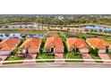 Aerial view showcasing a single-story home in a community setting near a lake at 10117 Colubrina Dr, Venice, FL 34293