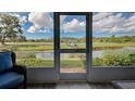 View through screen door onto a golf course and small lake at 1041 Capri Isles Blvd # 119, Venice, FL 34292