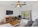 Comfortable living room featuring a ceiling fan and sliding glass doors to a screened patio at 11915 Tempest Harbor Loop, Venice, FL 34292