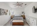 Bright main bedroom boasts a ceiling fan, board and batten accent wall, and ample natural light at 11915 Tempest Harbor Loop, Venice, FL 34292