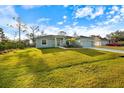 House with a large green lawn and driveway at 12385 Prudential Ave, Port Charlotte, FL 33981