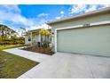 Light green house with a two-car garage and walkway at 12385 Prudential Ave, Port Charlotte, FL 33981