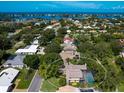 Breathtaking aerial view of a home, nestled in a lush, green neighborhood with a screened pool and waterfront access at 128 Sea Anchor Dr, Osprey, FL 34229