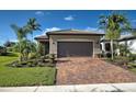 Front view of house with brown garage door and landscaped yard at 13463 Nobilio St, Venice, FL 34293