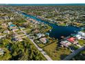 Aerial view of waterfront home with screened pool and lush landscaping, located on a canal with boat dock at 18053 Cullman Ave, Port Charlotte, FL 33948