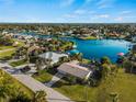 Aerial view of waterfront home with lush landscaping, and a beautiful water view of the canal and boat dock at 18053 Cullman Ave, Port Charlotte, FL 33948