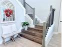 Elegant staircase featuring wood stairs, decorative railings, and a charming decorative mirror at 19836 Bridgetown Loop, Venice, FL 34293